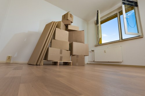 Professional movers carrying furniture through a North Kensington apartment hallway