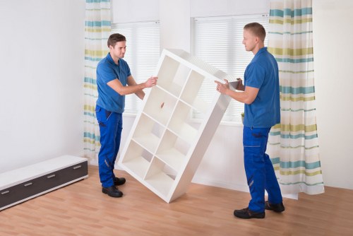 Removals crew carefully moving household items in Northkensington